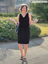 Miik founder Donna (5'6", small) smiling wearing Miik's Ada reversible draped cowl neck tank in black tucked in a pencil skirt in the same colour 