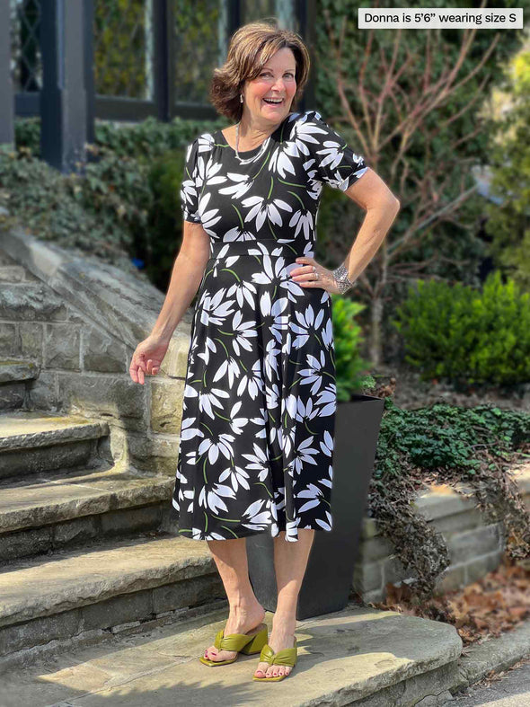 Miik founder Donna (5'6", small) smiling wearing Miik's Anika puff sleeve midi dress in white lily print reversed 