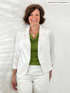 Miik founder Donna (5'6", small) smiling wearing Miik's Dorit boxy soft blazer in white with a pant in the same colour and a green moss top 