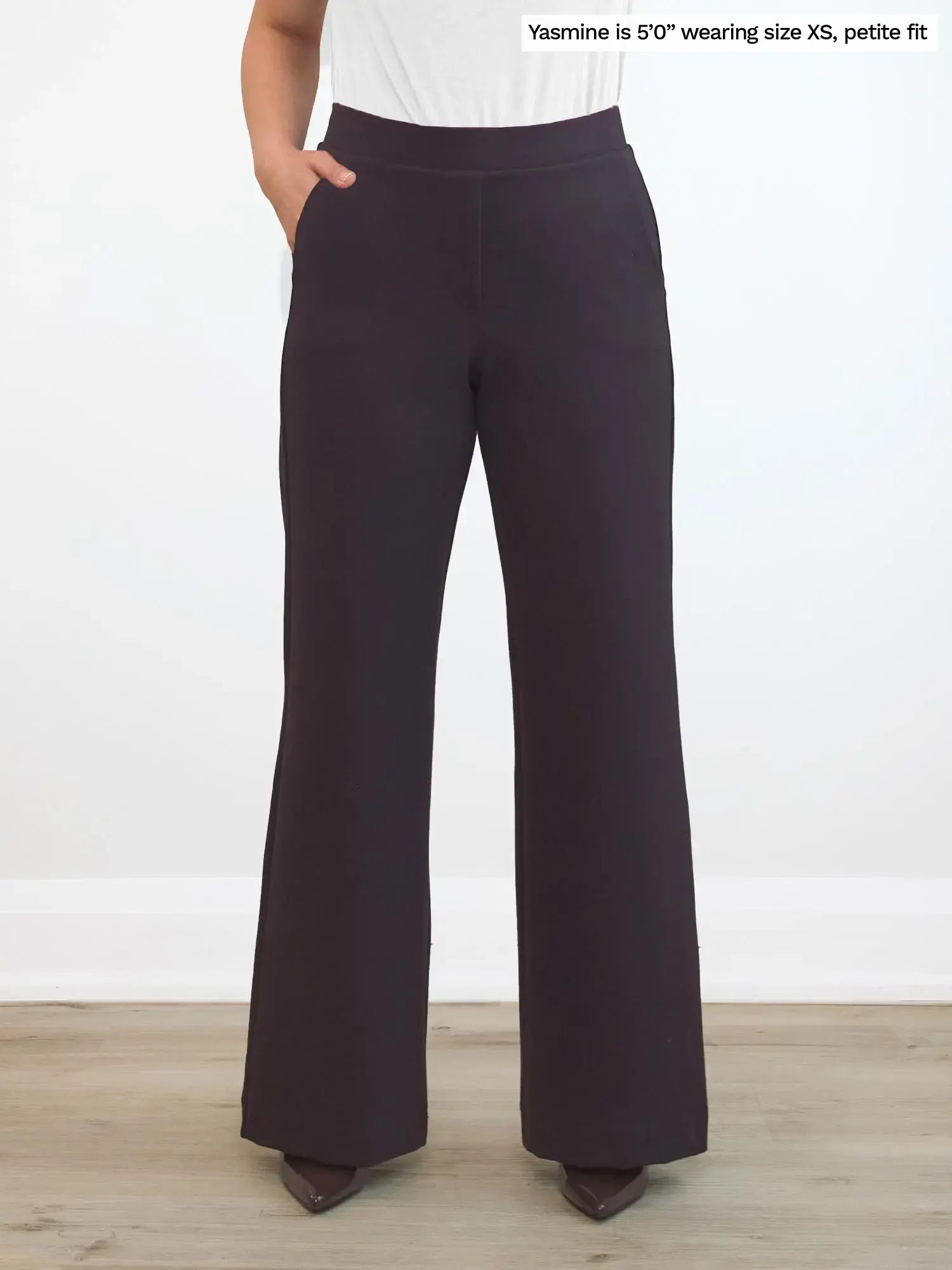 Dark brown petite wide-leg pants worn by a person on a white background