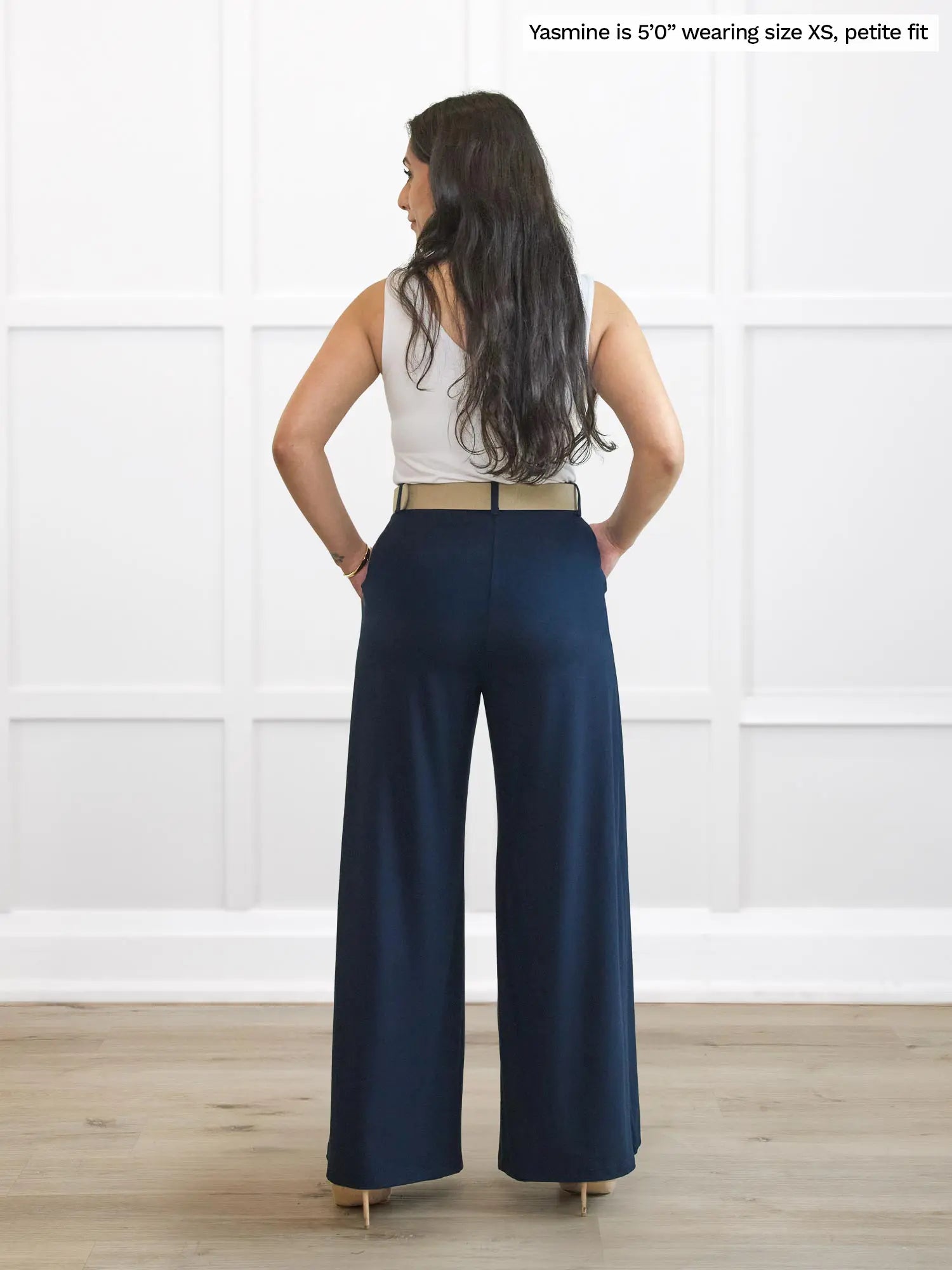 Miik model Yasmine (5’0”, xsmall, petite fit) standing with her back towards the camera showing the back of Miik&