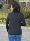 Miik model Meron (5’3”, xsmall) standing with her back towards the camera showing the back of Miik's Maeve LightLuxe washable blazer