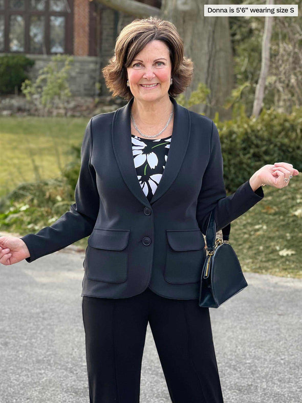 Miik founder Donna (5'6", small) smiling wearing Miik's Maeve LightLuxe washable blazer in graphite closed with a black pant 