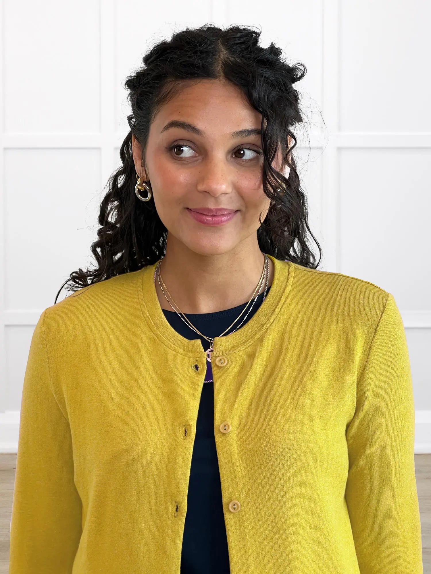 Woman wearing a yellow cardigan against a white background