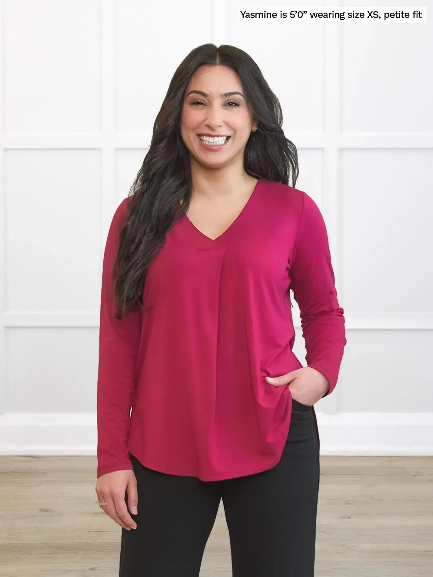 Woman wearing a red long-sleeve top against a white background