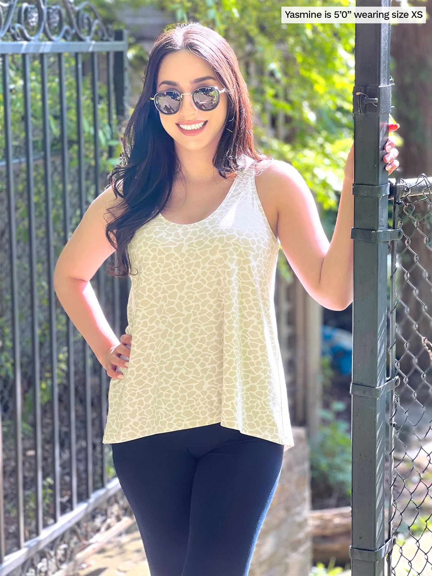 Miik model Yasmine (five feet tall, xsmall, petite) standing next to a gate in a backyard wearing Miik&