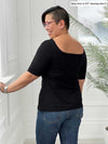 Miik model Mary-Ann (5'0", small)  standing with her back towards the camera showing the back of Miik's Shani reversible half sleeve square neck top in black