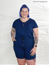 Miik model Kaitlin (5'9", xlarge) smiling wearing Miik's Tanya short sleeve open-back romper in ink blue