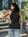 Miik model Meron (5’3”, xsmall) standing with her back towards the camera showing the back of Miik's Teanna high neck tank top
