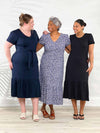 Miik models Bri, Keethai and Meron all smiling while standing next to each other wearing the new Miik's Zilma reversible puff sleeve midi dress in the three colours available: navy, baby's breath and black 