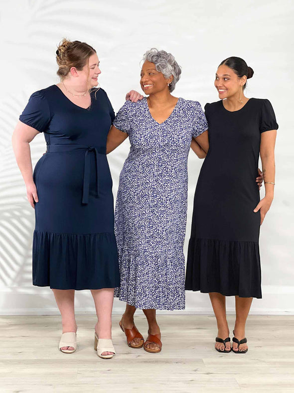 Miik models Bri, Keethai and Meron all smiling while standing next to each other wearing the new Miik's Zilma reversible puff sleeve midi dress in the three colours available: navy, baby's breath and black 