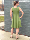 Miik model Johanna (five feet six, size extra small) standing with her back towards the camera showing the back of Miik's Valerie sleeveless fit and flare dress in green