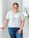 Miik model Bri (5'5", xlarge) smiling wearing Miik's Adisa reversible dolman top in white along with jeans and gold jewelry