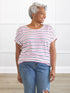 Woman wearing Miik sustainable striped dolman top and jeans, smiling indoors