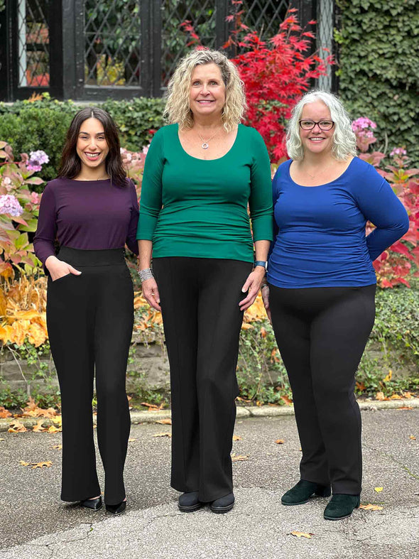 Miik models Yasmine, Carolyn and Colleen standing next to each other all wearing the same top: Miik's Akari side ruched reversible top. Yasmine is wearing in port, Carolyn in emerald green and Colleen in blueberry 