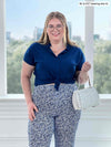 Bri (size XL, 5 foot 5) is wearing the Akira tulip hem capri in a small flowery print called baby's breath with a blue top.