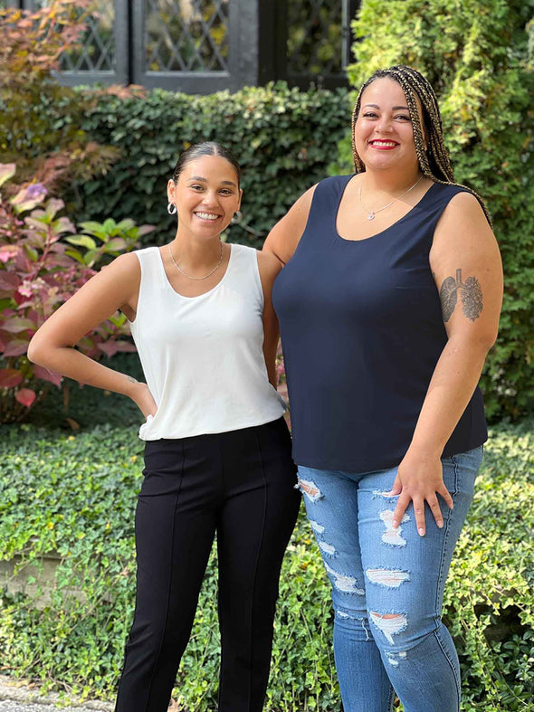 Miik model Sarita and Meron smiling while standing next to each other showing diversity of body sizes. Meron is xsmall while Sarita is 3x. Both are wearing similar Miik styles of tank top.
