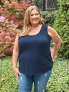 Miik model Kelly (5'7", size 3X, plus size) smiling and looking away wearing Miik's Alanis relaxed tank top in navy with jeans