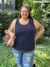 Miik model Sarita (5'7", size 2X, plus size) smiling wearing a ripped jeans with Miik's Alanis relaxed tank top in navy