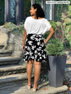 Miik model Meron (5’3”, xsmall) standing with her back towards the camera showing the back of Miik's Alara pocket swing skirt 
