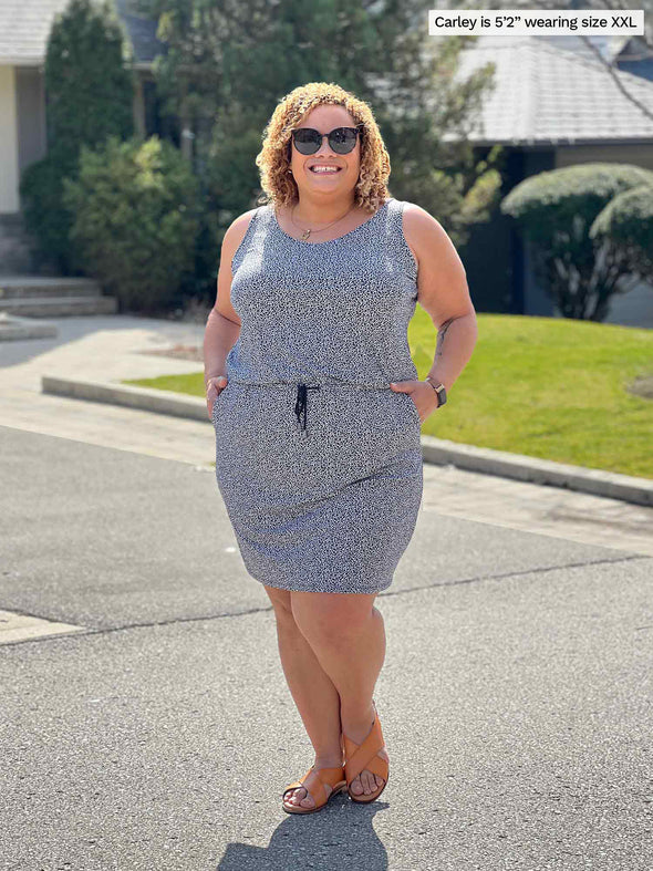Miik model Carley (5'2", xxlarge) smiling with hands on pockets wearing Miik's Amy drawstring pocket dress in pebble print 