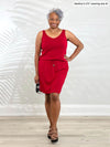 Miik model Keethai (5'5", medium) smiling wearing Miik's Amy drawstring pocket dress in poppy red 