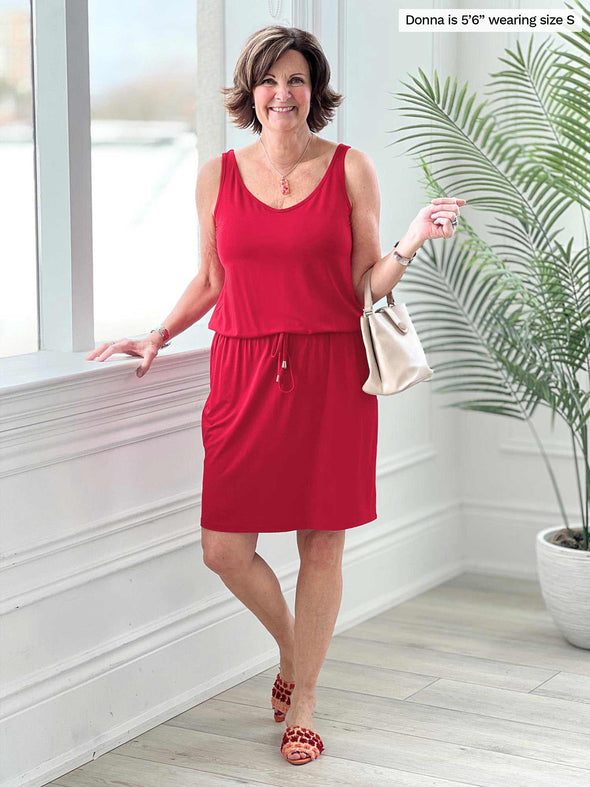 Miik founder Donna (5'6", small) smiling wearing Miik's Amy drawstring pocket dress in poppy red