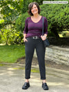 Miik founder Donna (5'6", small) smiling wearing a striped port v-neck long sleeve top tucked in Miik's Asia mid-rise slim pant regular length in charcoal, a black belt and loafer 