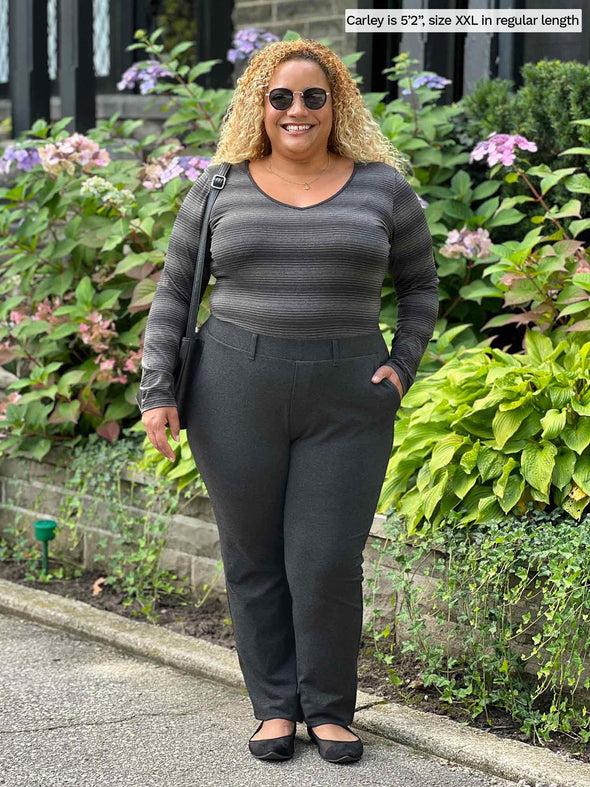 Miik model Carley (5'2", xxlarge) smiling wearing Miik's Asia mid-rise slim pant regular length in charcoal with a striped long sleeve in same colour
