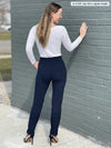 Miik model Johanna (five feet six, size xsmall) standing with her back towards the camera showing the back of Miik's Asia mid-rise slim pant