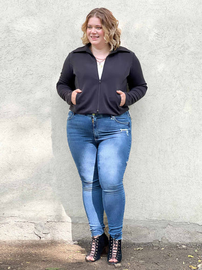 Miik model Bri (size XL, five foot five) wearing the Ayesha zipped jacket over a white tank with jeans.