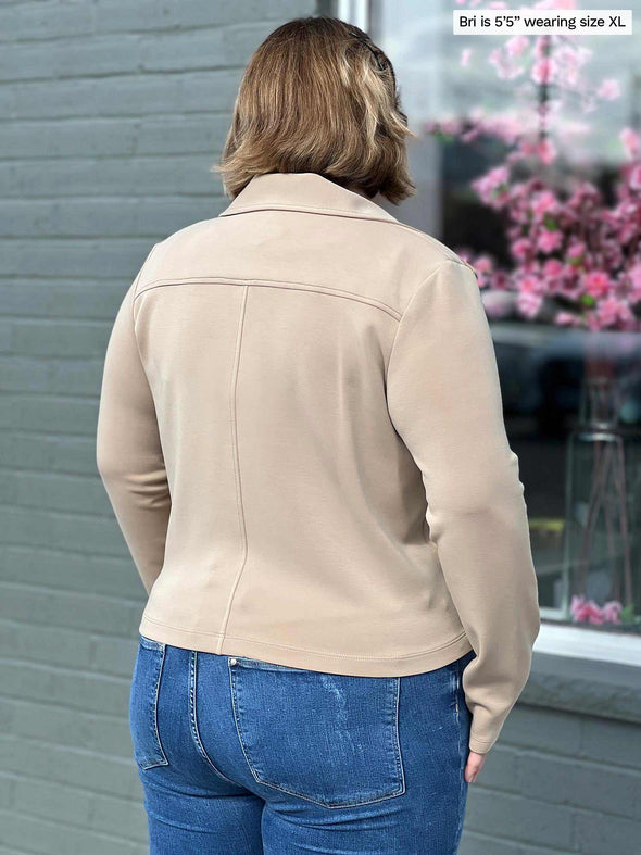 Miik model BRi (five feet five, size xlarge) standing with her back towards the camera showing the back of Miik's Ayesha zipped jacket