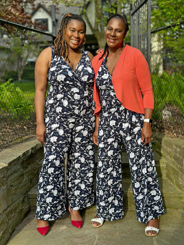 Miik models Raquel and Pat standing next to each other in a backyard wearing Miik's Blakely faux-wrap dressy jumpsuit both in blossom print