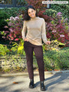 Miik model Meron (5'3", xsmall) smiling wearing Miik's Christal pull-on pintuck ankle pant in dark chocolate in the short length version with a wheat long sleeve top