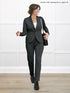 Woman wearing a gray suit with a white background 