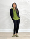 Miik model Lisa (5'6", xsmall) smiling wearing Miik's Christal pull-on pintuck ankle pant in black with a blazer in the same colour and a collared shirt in green moss