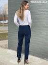 Woman standing with her back towards the camera wearing Miik's Christal pull-on pintuck dress pant in navy with a white shirt.