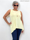 Woman standing in front of a wall wearing Miik's Dalya high-low flowy tunic tank in yellow with navy leggings.