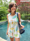 Woman standing in front of a pool wearing Miik's Dalya high-low flowy tunic tank as swimsuit coverup in leaf pattern.