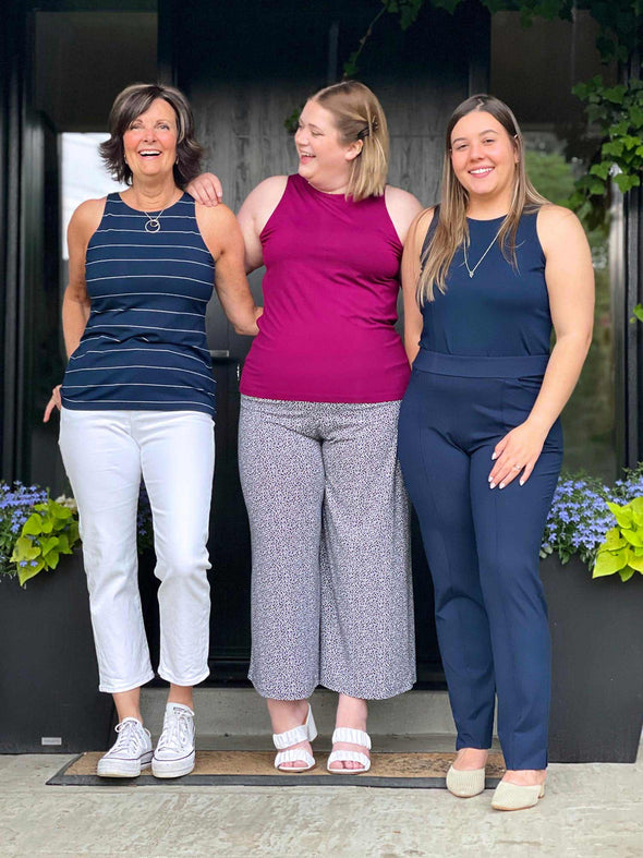 Miik founder Donna, and models Bri and Christal standing next to each other all wearing Miik's Dolly high neck tank top. Donna is wearing in the navy wide pinstripe colour, Bri in ruby and Christal in navy solid.