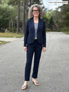 Miik model Liane (5'9", small) smiling wearing a navy suit: Emily soft blazer with Christal pant along with a tank top in baby's breath print 