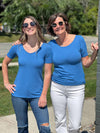 Miik founder Donna (five feet six, small) and model Johanna (five feet six, xsmall) smiling while standing next to each other both wearing Miik's Emmy reversible half sleeve top in cobalt melange 