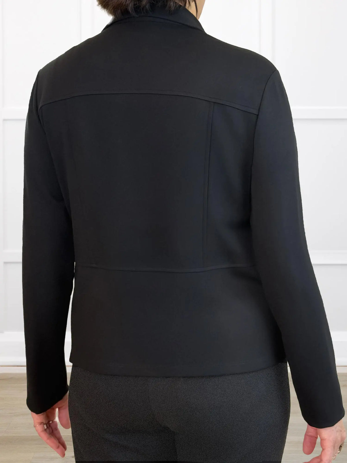 Black jacket worn by a person on a white background 