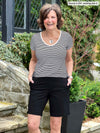 Miik founder Donna (5'6", small) laughing wearing a mini stripe black and white tee with Miik's Irelynn bermuda pocket short in black 