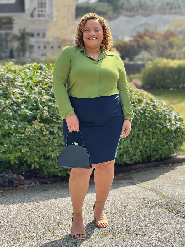 Miik model Carley (5'2", xxlarge) smiling wearing Miik's Jilly pull-on pencil skirt in navy and a collared shirt in green moss