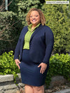 Miik model Carley (5'2", xxlarge) smiling wearing Miik's Jilly pull-on pencil skirt in navy, a blazer in the same colour and a collared shirt in green moss 