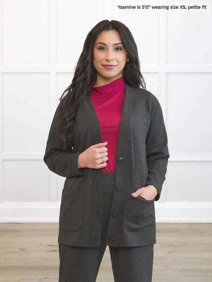 Woman wearing a gray blazer and pink shirt against a white background 