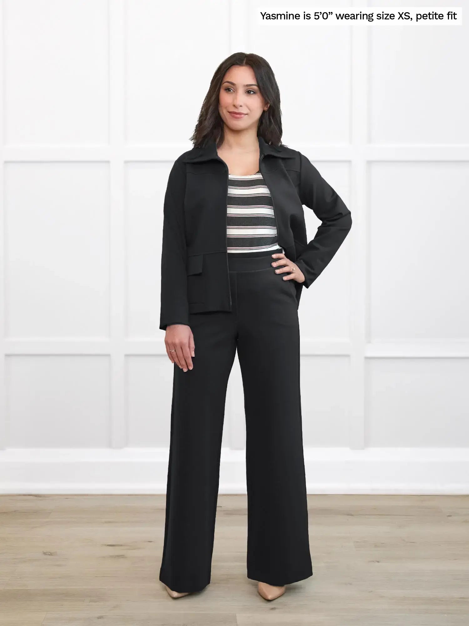 Woman wearing a black outfit with a striped top against a white background 