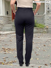 Miik model Meron (5’3”, xsmall) standing with her back towards the camera showing the back of Miik's Keltie ponte mid-rise slim pant