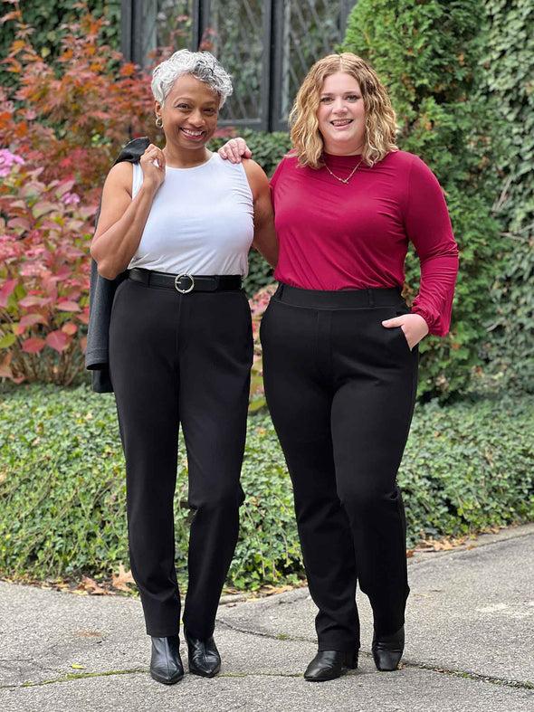 Miik models Keethai and Bri smiling standing next to each other wearing Miik's Keltie ponte mid-rise slim pant in black